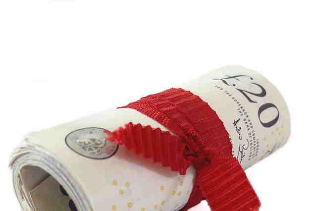 Roll of bank notes in a red ribbon
