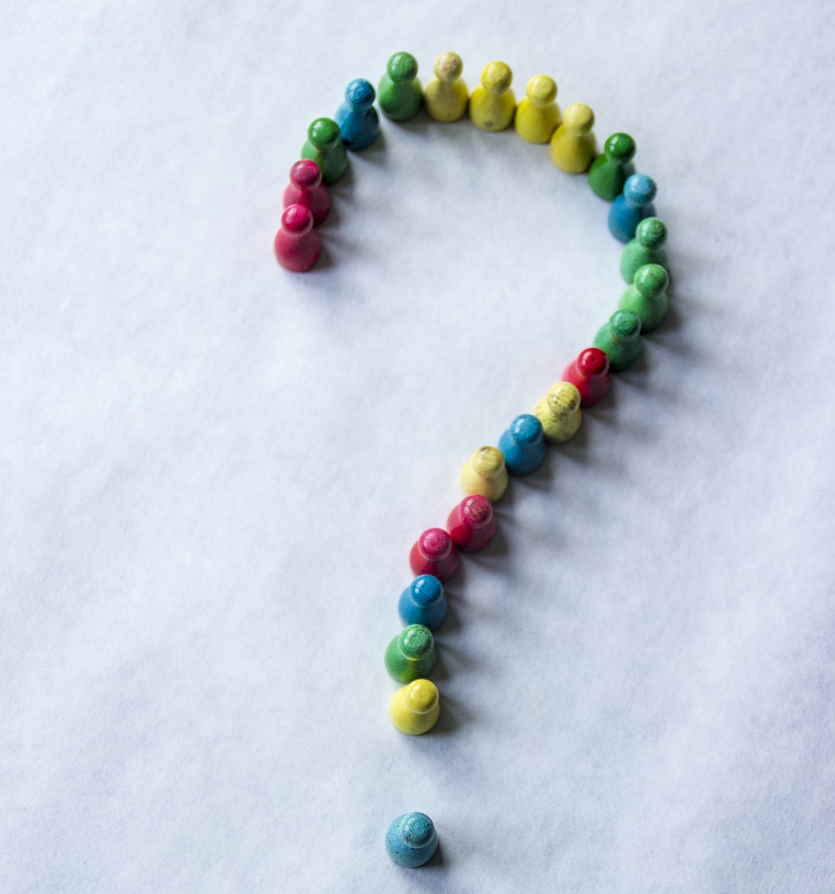 Question mark made from small wooden skittles ready to tumble